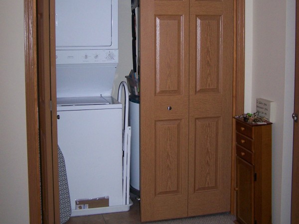 A washer and dryer unit in the closet